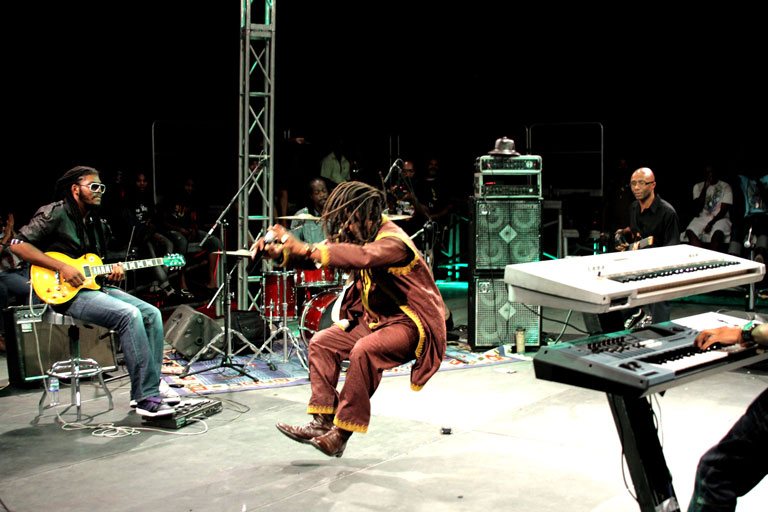 Kaplawsé sur scène avec musiciens et instruments